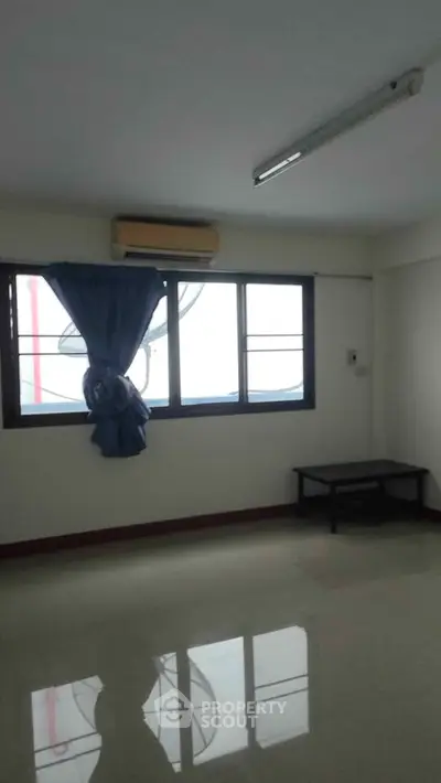 Spacious unfurnished room with large window and air conditioning, ideal for customization.