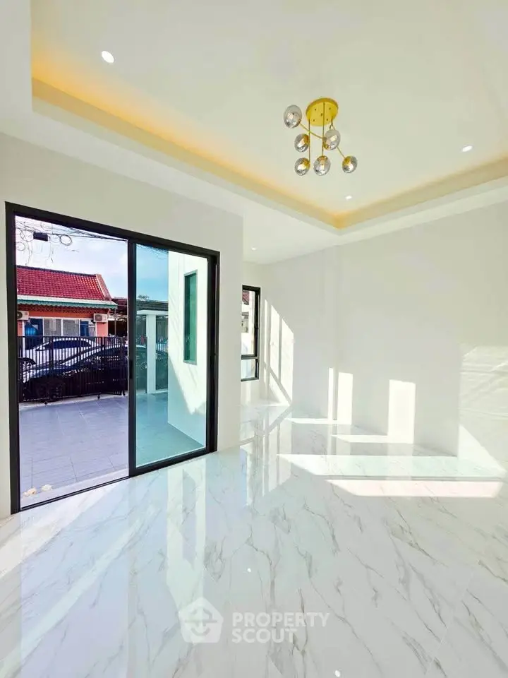 Spacious modern living room with marble flooring and large sliding glass doors opening to a balcony.