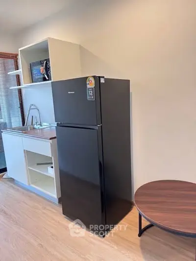 Modern kitchen with sleek black fridge and minimalist design