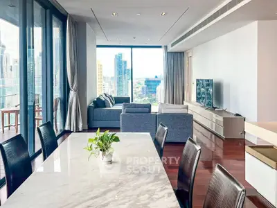 Luxurious open-plan living room with stunning city view and elegant dining area.