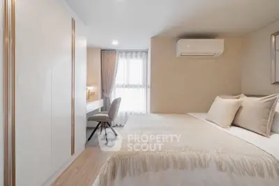 Cozy and modern bedroom with elegant decor and ample natural light, featuring a stylish workspace.