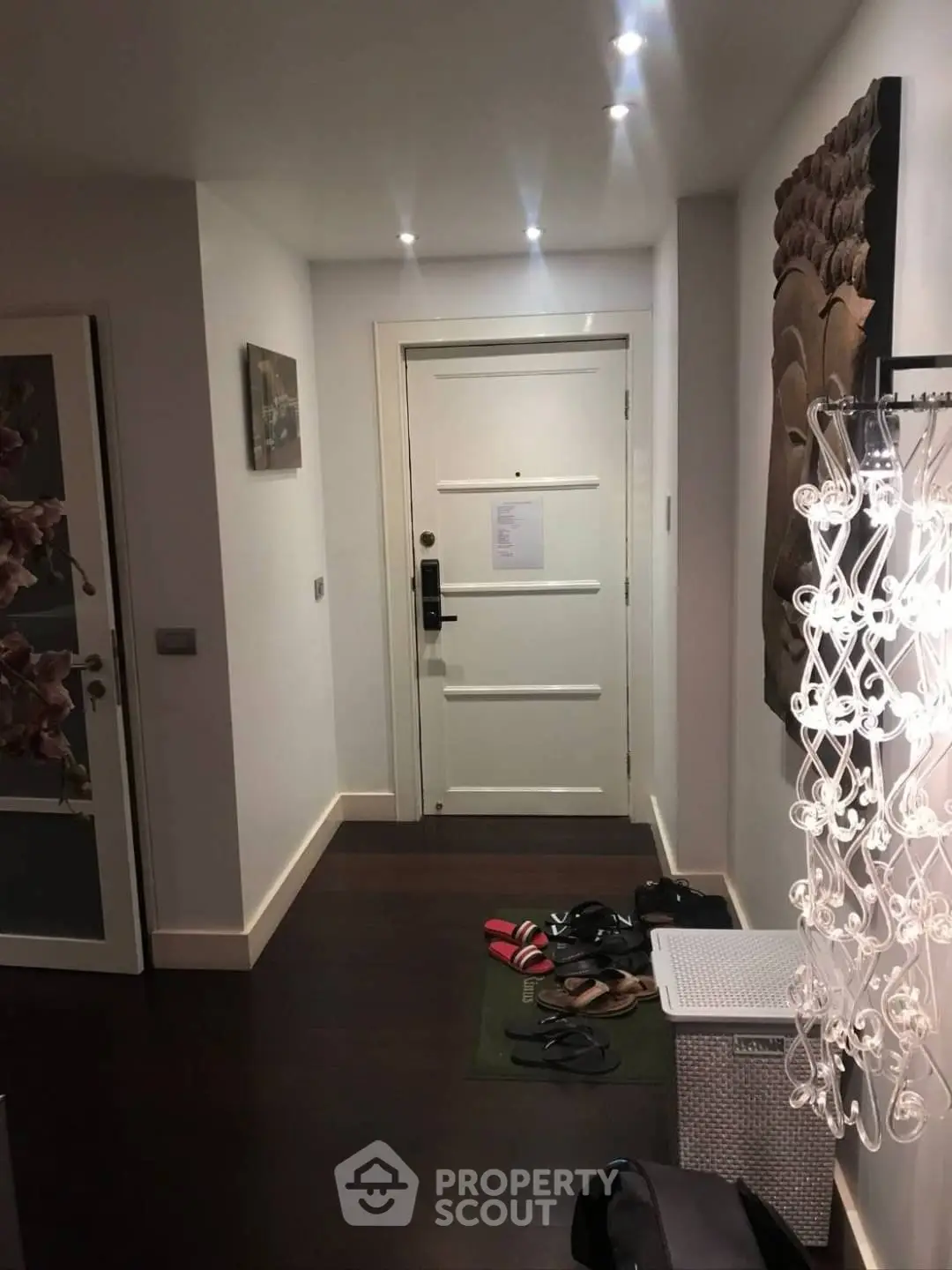 Chic apartment entrance with dark wood flooring and modern decor