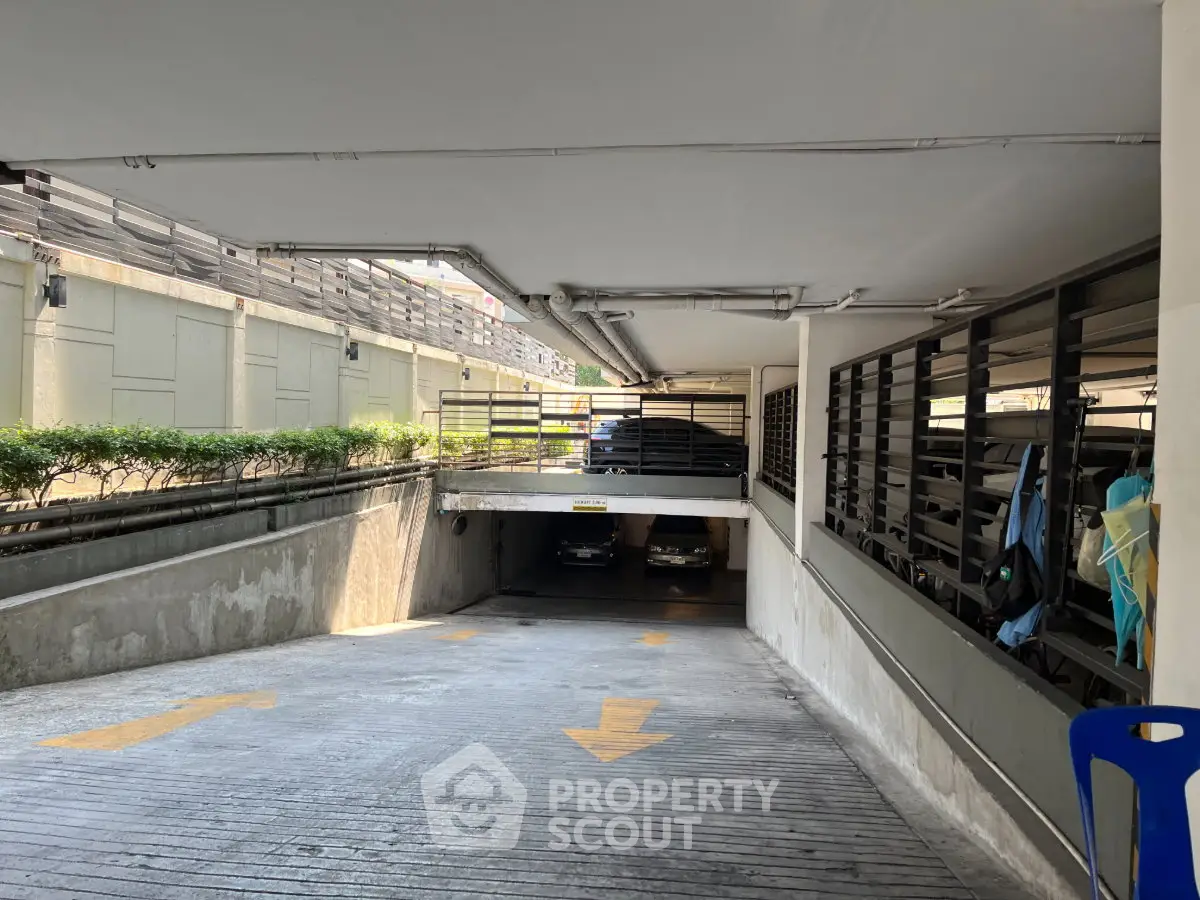 Secure underground parking entrance with ample space and clear directional signage.