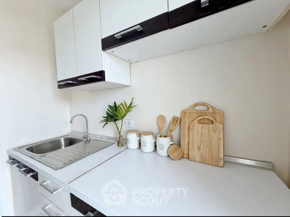 Modern kitchen with sleek cabinetry and stainless steel sink, perfect for culinary enthusiasts.