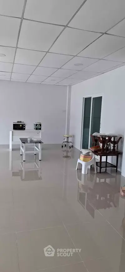 Spacious interior with modern furniture and sleek tiled flooring, perfect for versatile living arrangements.