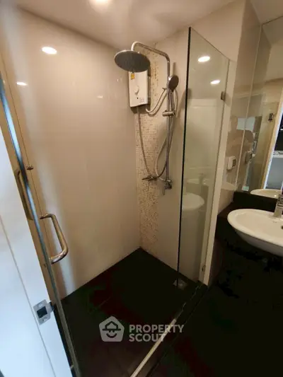 Modern bathroom with glass shower enclosure and sleek fixtures