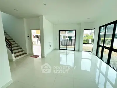 Spacious modern living room with large windows and glossy tile flooring in a bright home.