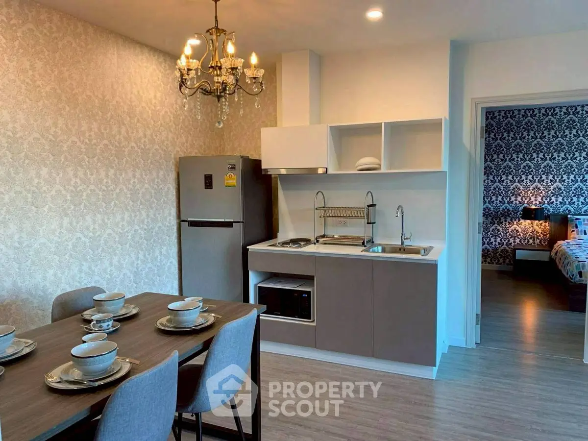 Modern open kitchen with dining area and view into stylish bedroom