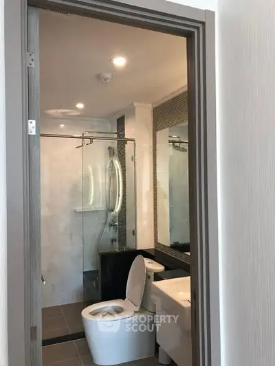 Modern bathroom with glass shower and sleek fixtures in a stylish apartment.
