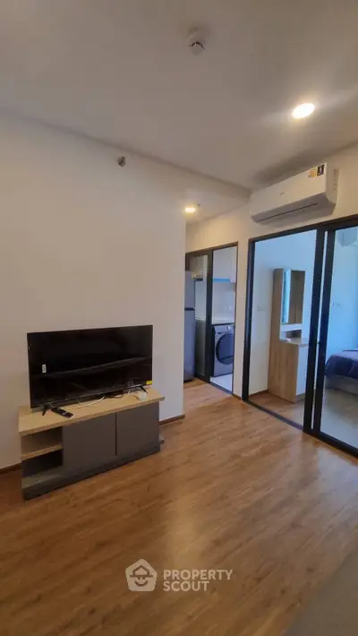 Modern living room with wooden flooring and sleek TV setup