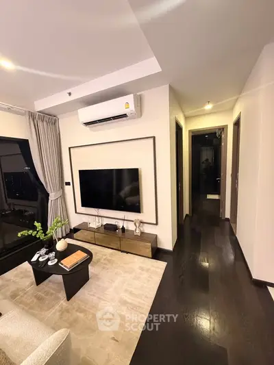 Modern living room with sleek design, featuring a wall-mounted TV, stylish furniture, and ambient lighting.