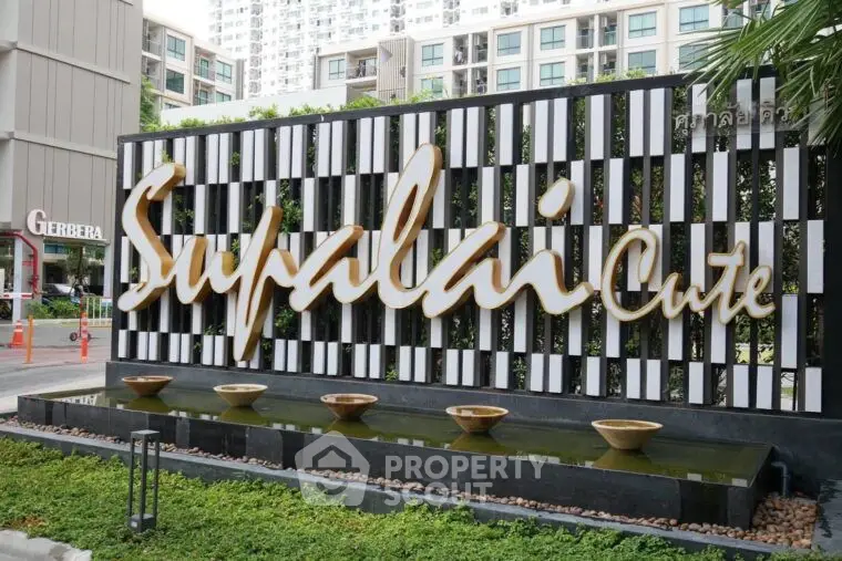 Modern Supalai Cute building entrance with stylish water feature and lush greenery.