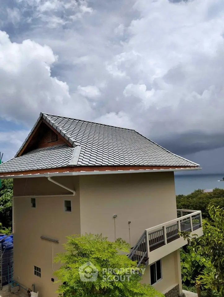 Stunning coastal view from modern hillside home with unique architecture and lush surroundings.