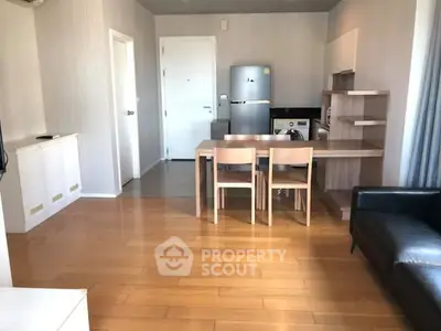 Modern open-plan living room with sleek kitchen and wooden flooring