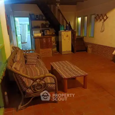 Charming rustic-style living space with terracotta tiles and wicker furniture, offering a cozy and inviting atmosphere for relaxation.