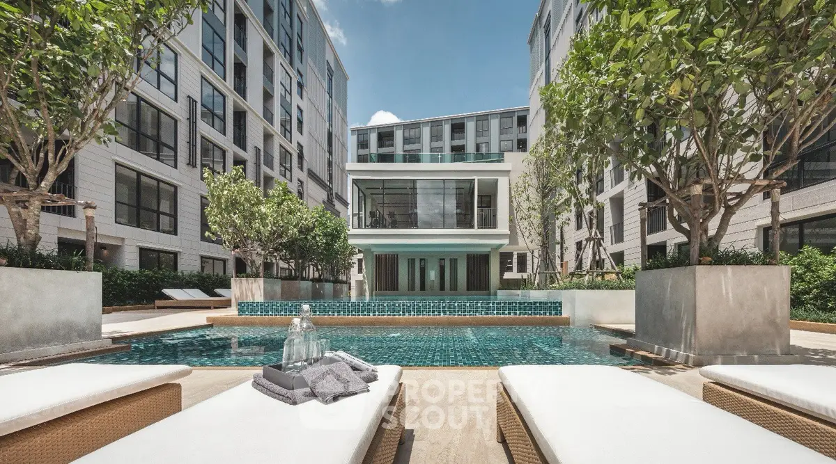 Luxurious apartment complex with modern pool and lush greenery, perfect for relaxation and leisure.