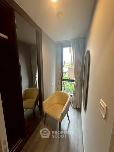 Cozy small room with modern chair and window view, perfect for a reading nook or compact study area.