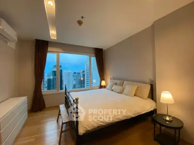 Spacious bedroom with city view, featuring a large bed and modern decor, perfect for urban living.