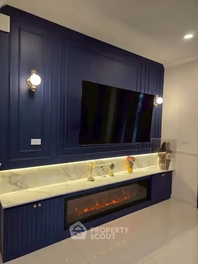 Luxurious living room with elegant fireplace and mounted TV, featuring stylish lighting and marble accents.