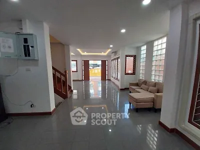 Spacious modern living room with sleek tile flooring and cozy seating area, perfect for family gatherings.