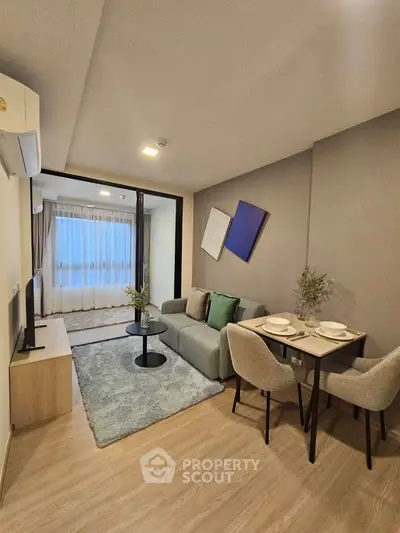 Modern living room with cozy seating and dining area, featuring stylish decor and natural light.