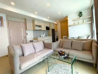 Modern living room with cozy sofas and open kitchen layout in a stylish apartment.