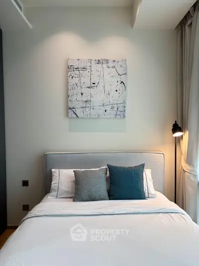 Modern bedroom with stylish decor and cozy lighting, featuring a comfortable bed and elegant wall art.