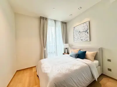 Serene bedroom with plush bedding, hardwood floors, and ample natural light filtering through sheer curtains, creating a tranquil retreat.
