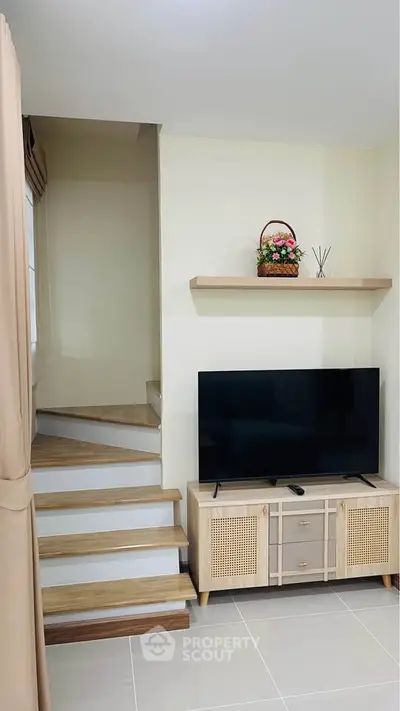 Modern living room with TV and stylish staircase
