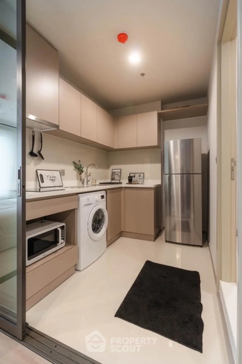 Modern kitchen with sleek appliances and washing machine in compact layout
