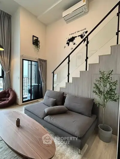Modern living room with stylish decor and mezzanine, featuring a cozy sofa and large windows for natural light.