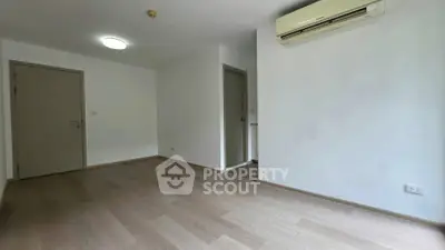 Spacious empty room with wooden flooring and air conditioning, perfect for customization.