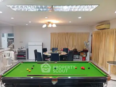 Spacious living room with pool table and dining area, perfect for entertainment and relaxation.