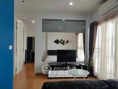 Modern living room with TV, air conditioning, and large window in stylish apartment.