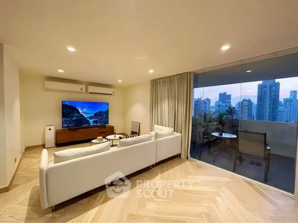 Luxurious living room with city view and spacious balcony in modern apartment.