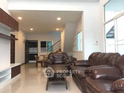 Spacious living room with leather sofas and modern decor in a bright, open layout home.