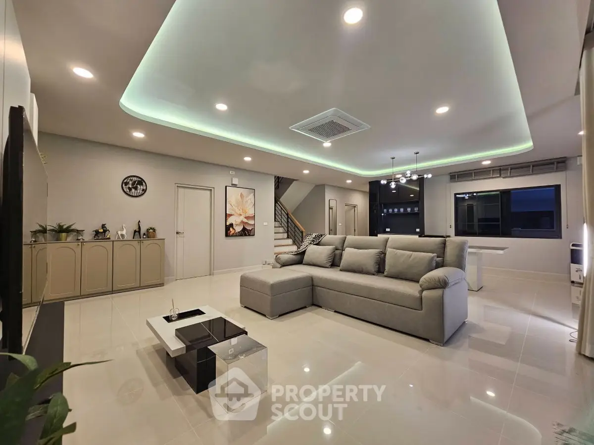 Spacious modern living room with sleek design and ambient lighting, perfect for relaxation and entertainment.