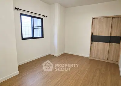 Spacious bedroom with wooden flooring and built-in wardrobe, perfect for modern living.