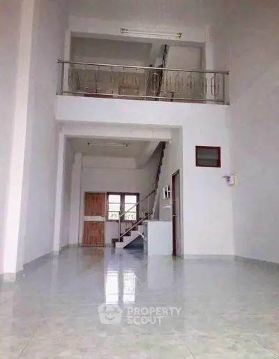 Spacious modern interior with high ceilings and mezzanine, perfect for open living.