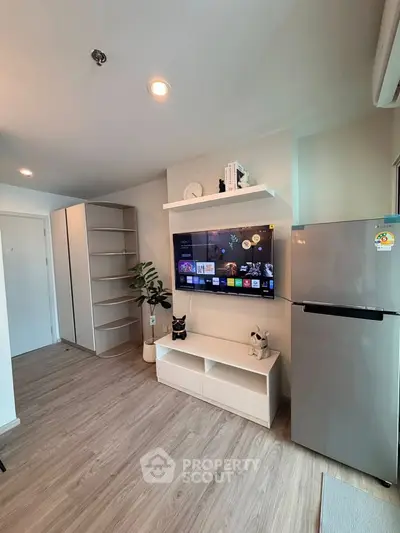 Modern living room with sleek TV setup and stylish shelving in a cozy apartment.