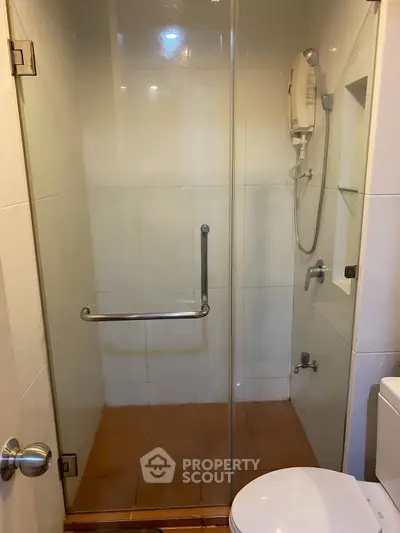 Modern bathroom with glass shower enclosure and sleek fixtures.