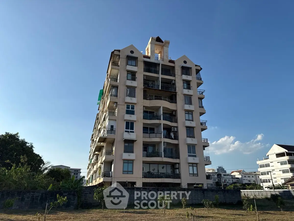 Stunning multi-story residential building with balconies and clear blue sky backdrop.