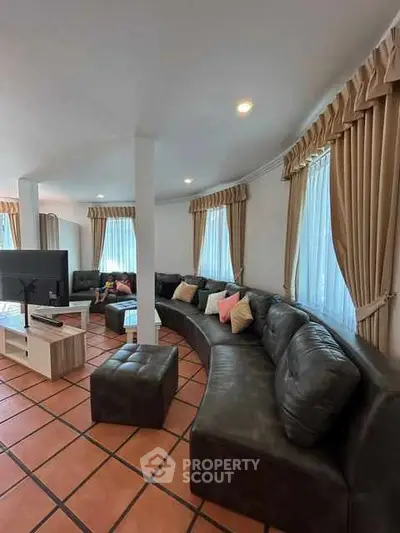 Spacious living room with elegant curved sofa and large windows