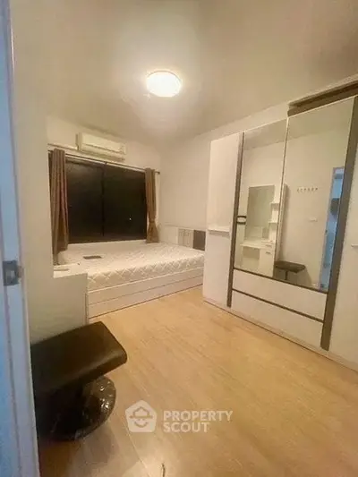 Cozy bedroom with modern furnishings and ample storage space, perfect for comfortable living.