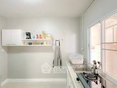 Modern kitchen with sleek design, featuring open shelving and gas stove, perfect for culinary enthusiasts.