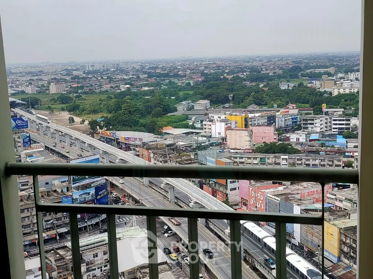 Stunning cityscape view from a high-rise balcony overlooking urban landscape and transportation routes.