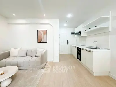 Modern open-layout living room and kitchen with sleek design and neutral tones.