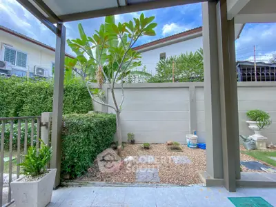 Charming garden view from modern patio with lush greenery and blue sky