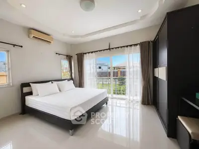 Spacious bedroom with large windows and modern furnishings, offering abundant natural light and serene views.