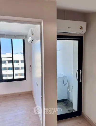 Modern apartment with air conditioning and laundry area, featuring sleek design and ample natural light.